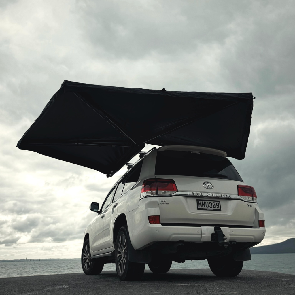 Stoke Mako 270 awning fanned open over the rear of a Toyota Land Cruiser, rear three-quarter view