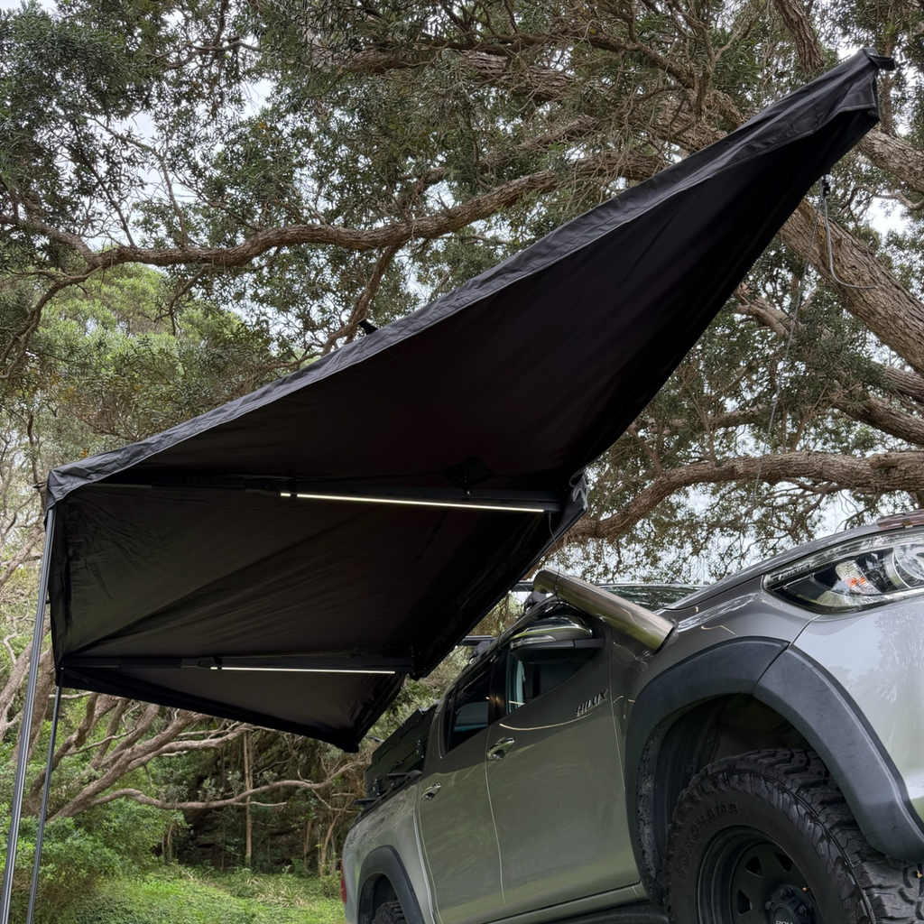 Stoke Mako 180 batwing awning being swung open and deployed beside a vehicle