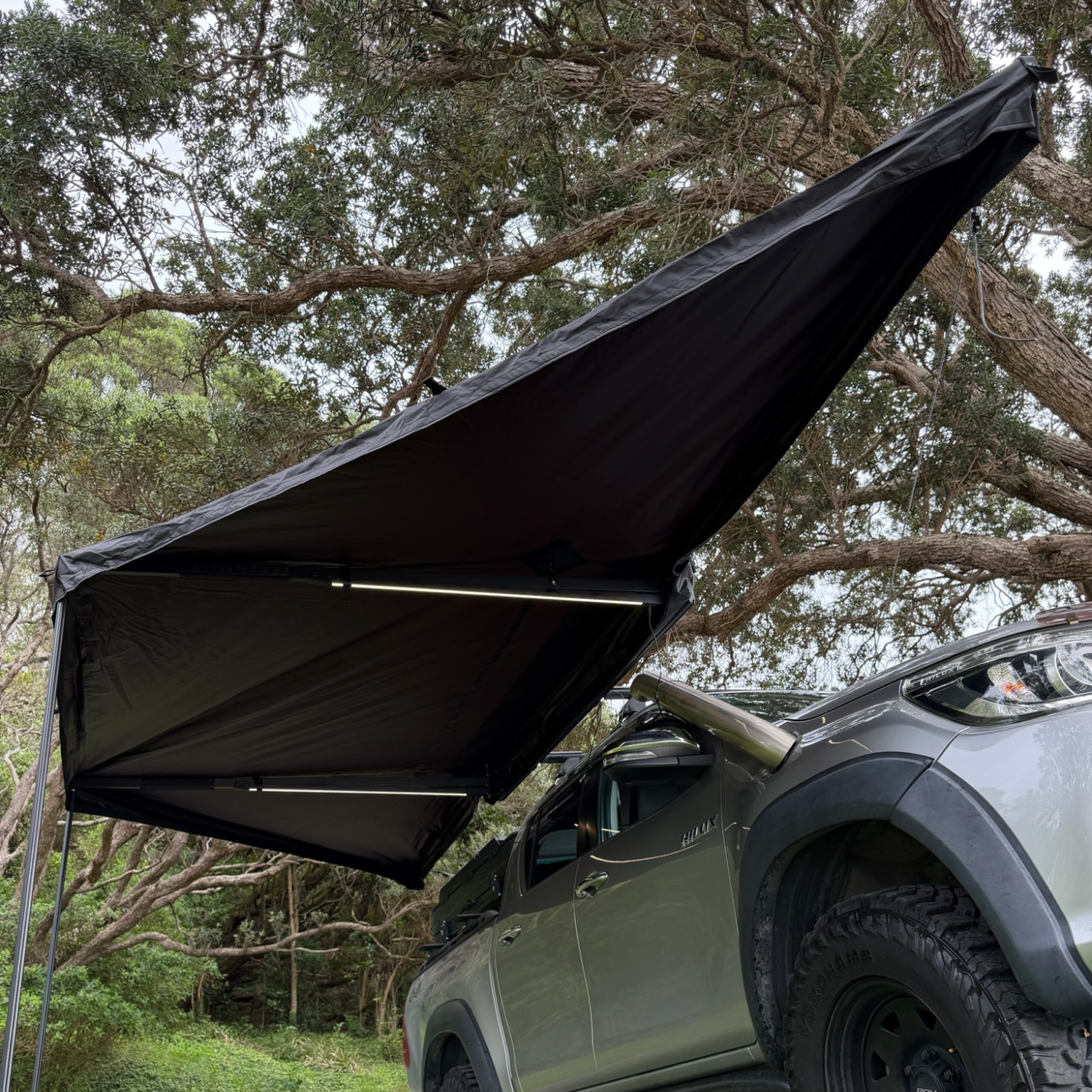 Stoke Mako 180 batwing awning being swung open and deployed beside a vehicle