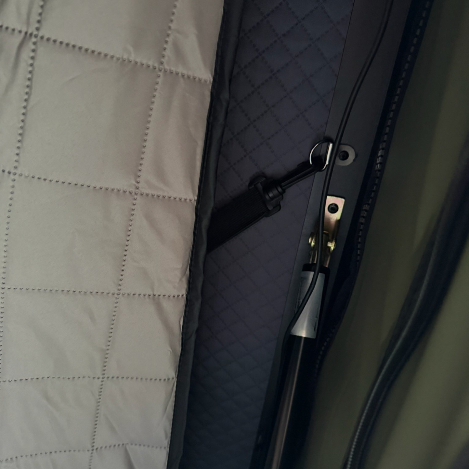Close-up of the Stoke insulation liner attached to the tent wall beside a gas strut and zip fastening