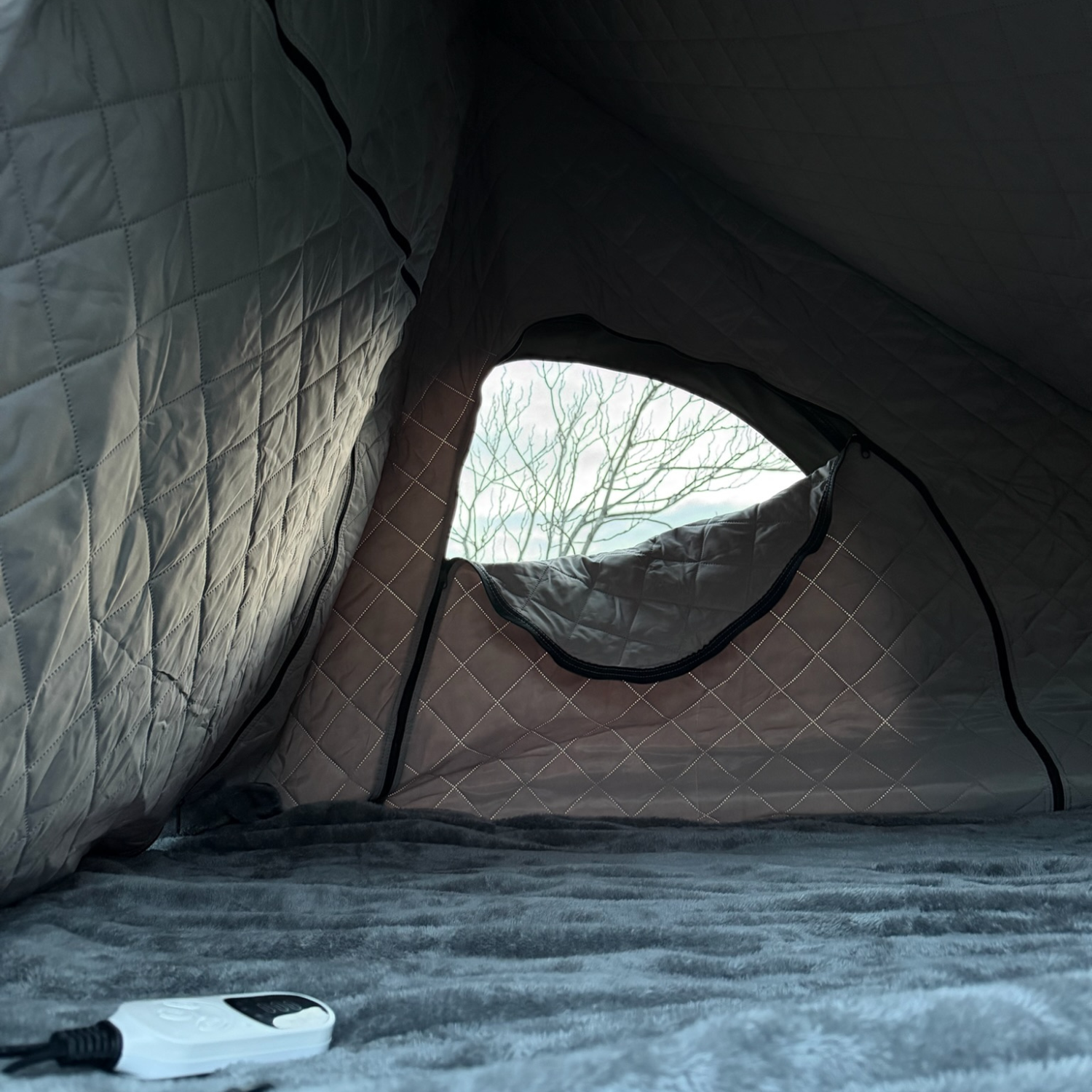 Stoke Electric Blanket XL fitted across a rooftop tent bed, white heat controller and cord visible